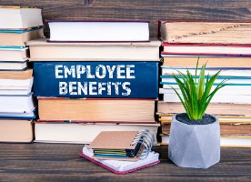 stack of books with employee benefits written on one